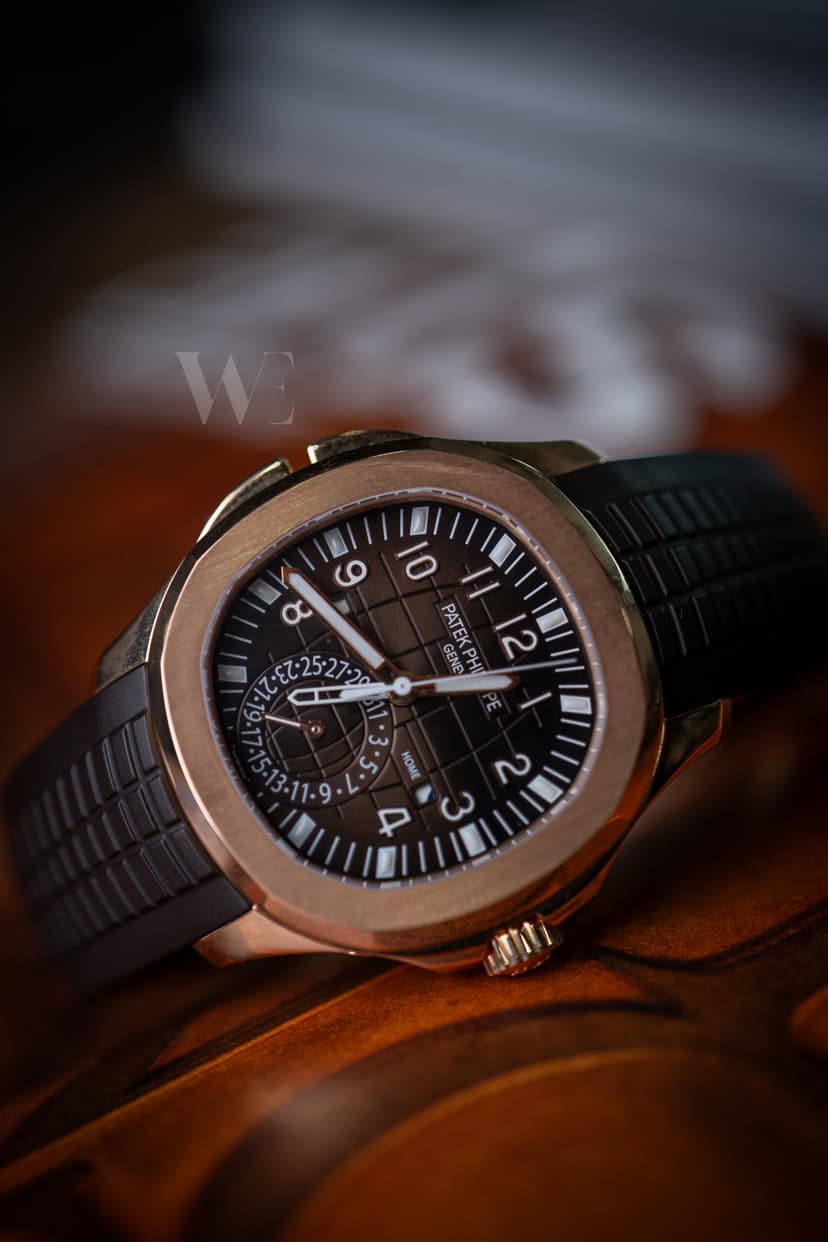 Montre Patek Philippe à boîtier rosé et cadran brun sur bracelet en caoutchouc, posée sur du cuir